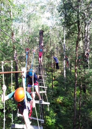 Students climbing on horizontal rope ladder