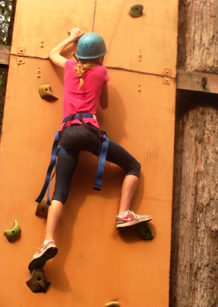 Girl climbing vertical wall